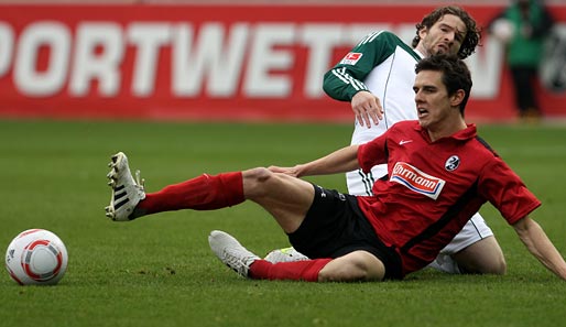 Johannes Flum, hier im Zweikampf mit Arne Friedrich, bleibt dem SC Freiburg erhalten