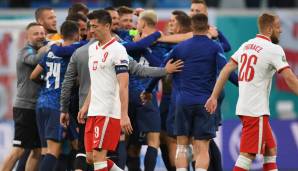 Robert Lewandowski geht enttäuscht vom Platz, im Hintergrund feiern die gegen Polen siegreichen Slowaken.