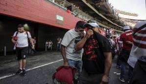 Fans von River Plate schützen ihr Gesicht vor Pfefferspray, das von der Polizei versprüht wurde.