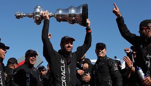 Ben Ainslie (M.) mit der Siegerstrophäe des America's Cup