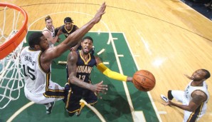 Paul George (M.) und Derrick Favors (l.) liefern sich einen heftigen Schlagabtausch